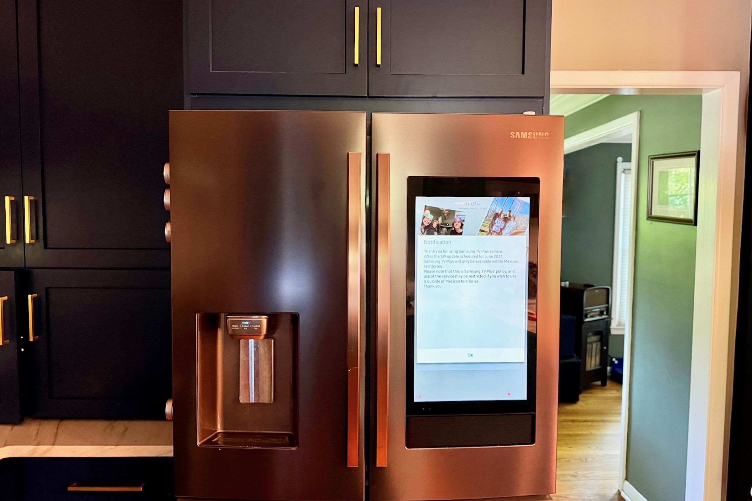 A fridge with a tablet screen in a kitchen.