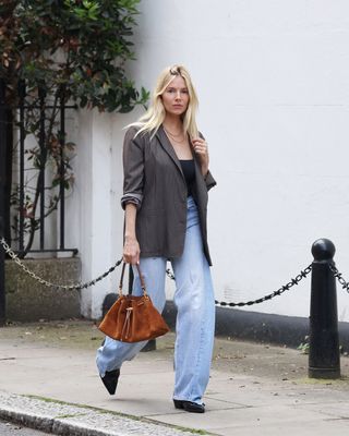 Sienna Miller wears a blazer with high waisted jeans.