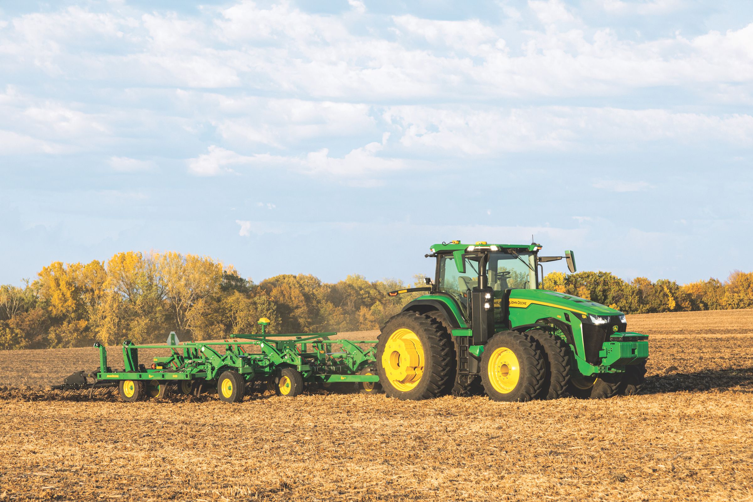 A John Deere Tractor driving in a field.