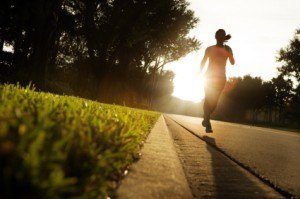 woman running on road at sunrise