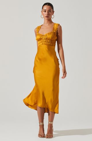 a model wears a marigold yellow sleeveless dress