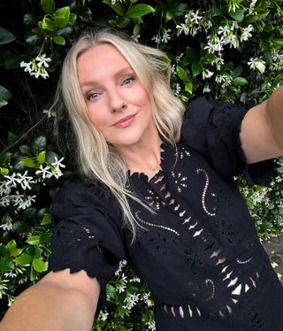 Photo of Laura Brown wearing black shirt against green leaf background.