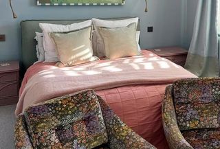 Stylist bedroom featuring the best luxury mattress, a pink duvet cover, and stylish printed ottomans.