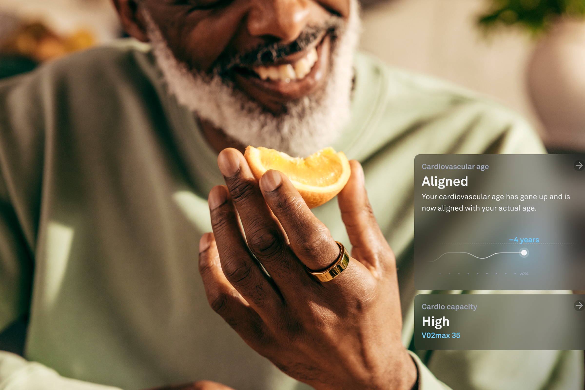 Man eating orange while wearing Oura Ring with a render of the new cardiovascular age feature.