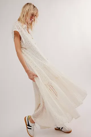 a model wears a maxi white eyelet dress