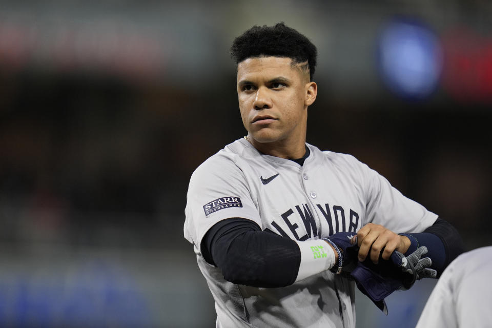 New York Yankees' Juan Soto takes off his gloves after a walk during the eighth inning of a baseball game against the San Diego Padres, Saturday, May 25, 2024, in San Diego. (AP Photo/Gregory Bull)