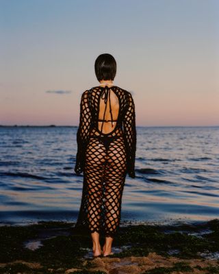 Model in front of sea wearing Nia Thomas High Priestess Dress