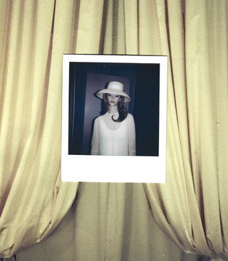 Polaroid of woman wearing wide-brim Mains de Vapeur hat.