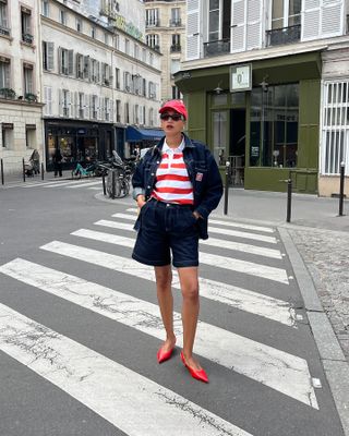 a woman wears a red and white striped T-shirt with denim shorts