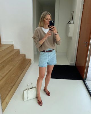 Woman wearing a sweater with denim shorts