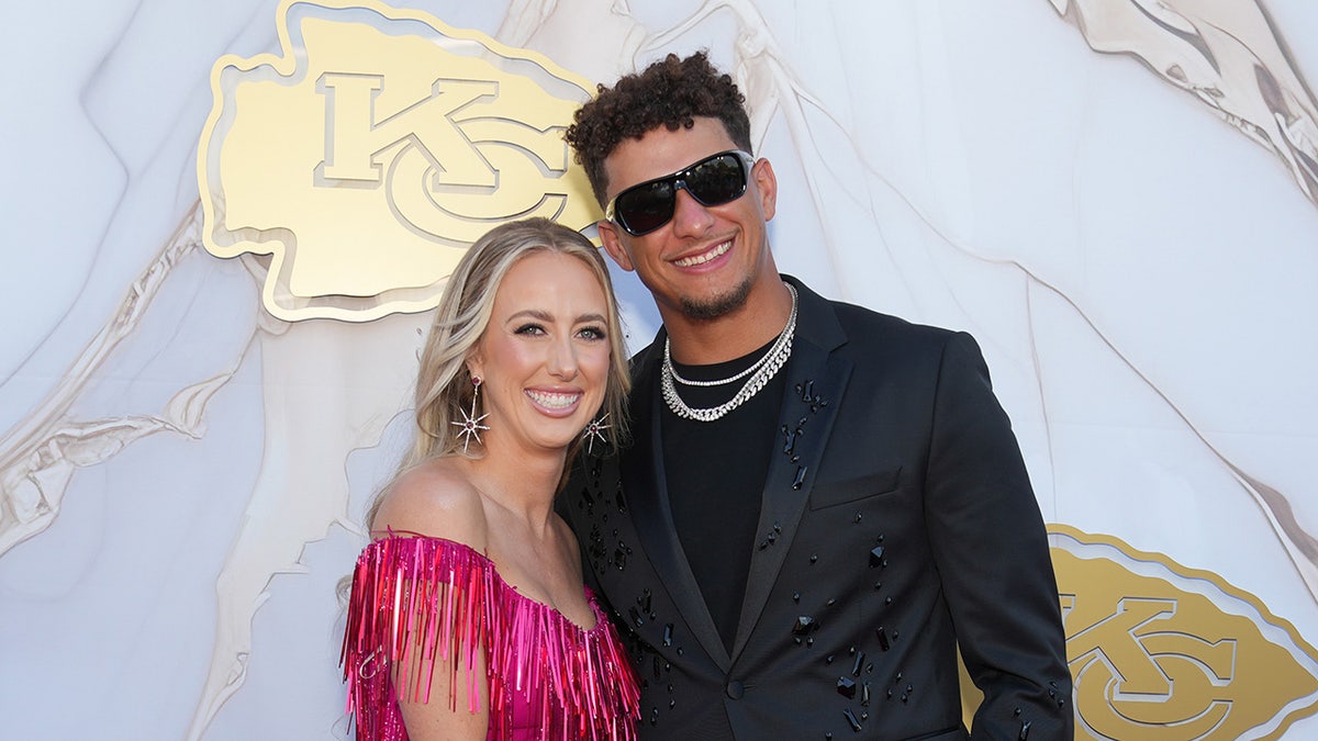 Patrick Mahomes and Brittany Mahomes pose for a photo