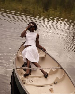 Woman in white linen top and skirt.