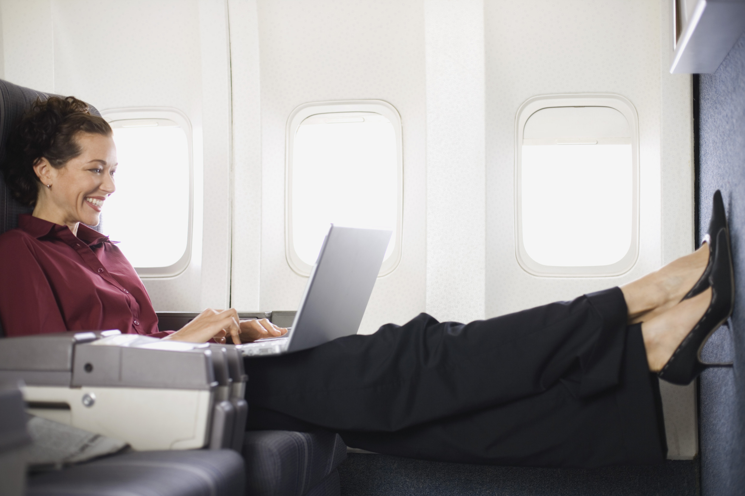 Woman on plane with legs stretched out.