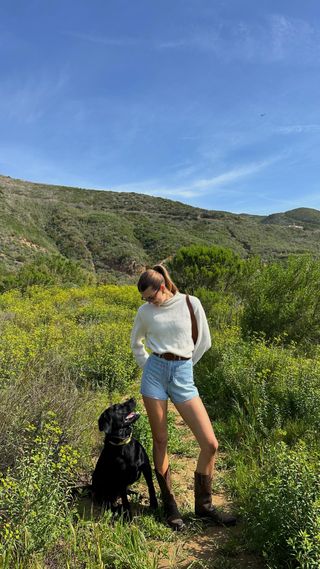 Influencer wears cowboy boots with a summer outfit.