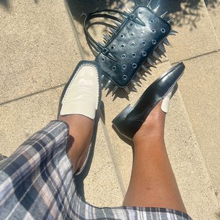 chichi wears dolce vita black and white beny loafer near a spiked handbag in a flat lay