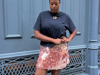 @champagnemani in a blue T-shirt and pink sequin J.Crew miniskirt.