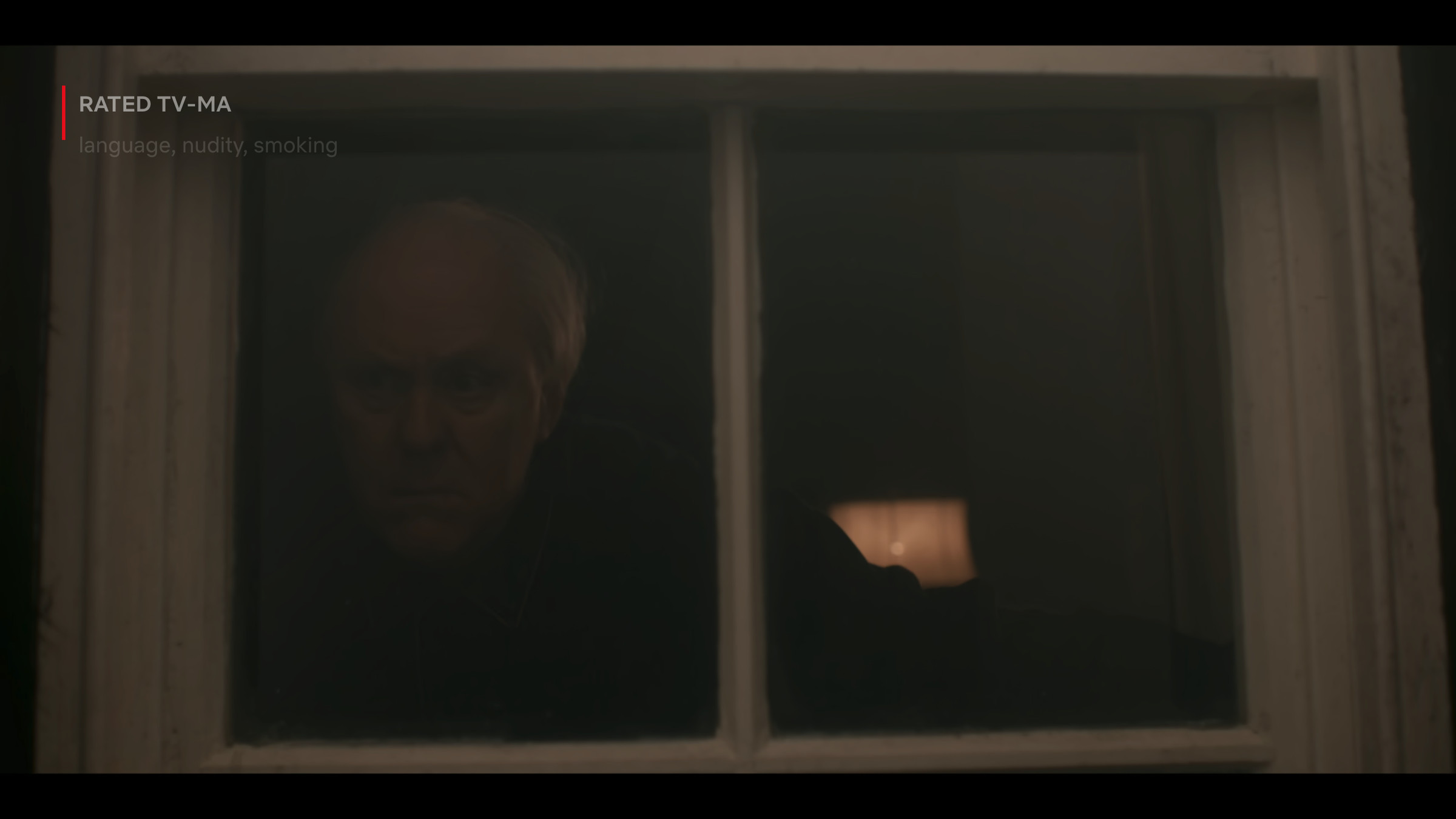 An image of John Lithgow, as Winston Churchill, peering into the smog.