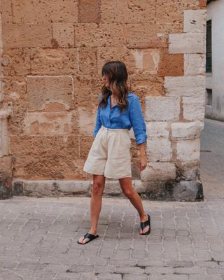 Influencer wears long shorts and thong sandals.