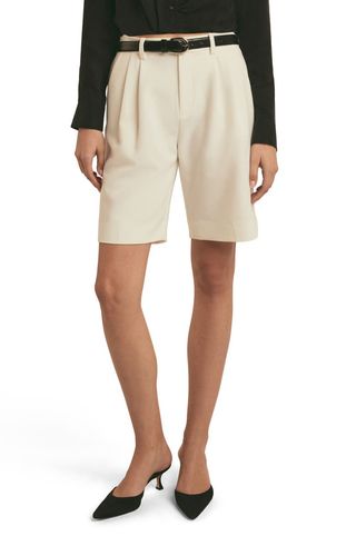 a model wears beige bermuda shorts by Favorite Daughter 