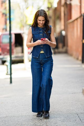 Katie Homes wears jeans and loafers.