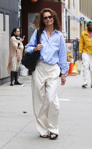 Katie Homes wears cream trousers with chunky sandals.