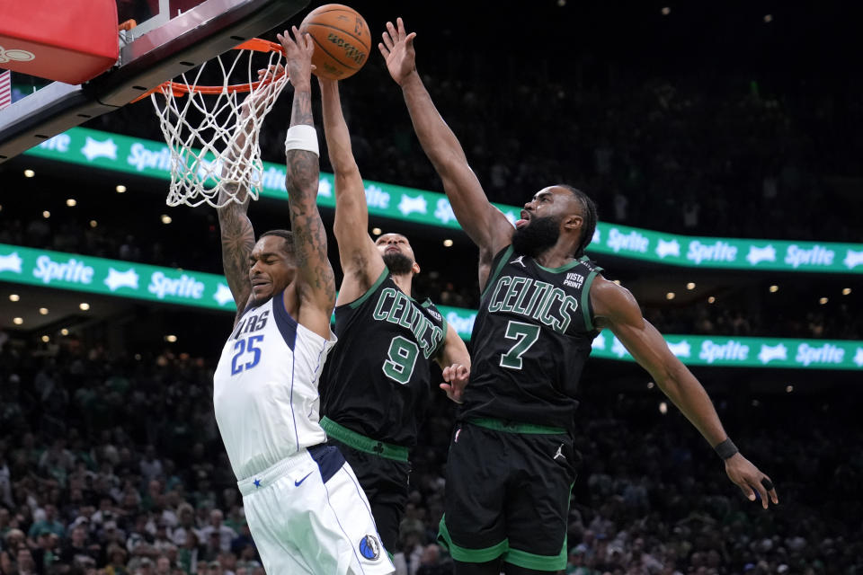 A P.J. Washington (25), de los Mavericks de Dallas, le bloquean un intento de retacada Derrick White (9) y Jaylen Brown (7), de los Celtics de Boston, durante la segunda mitad del Juego 2 de las Finales de la NBA, el domingo 9 de junio de 2024, en Boston. (AP Foto/Steven Senne)