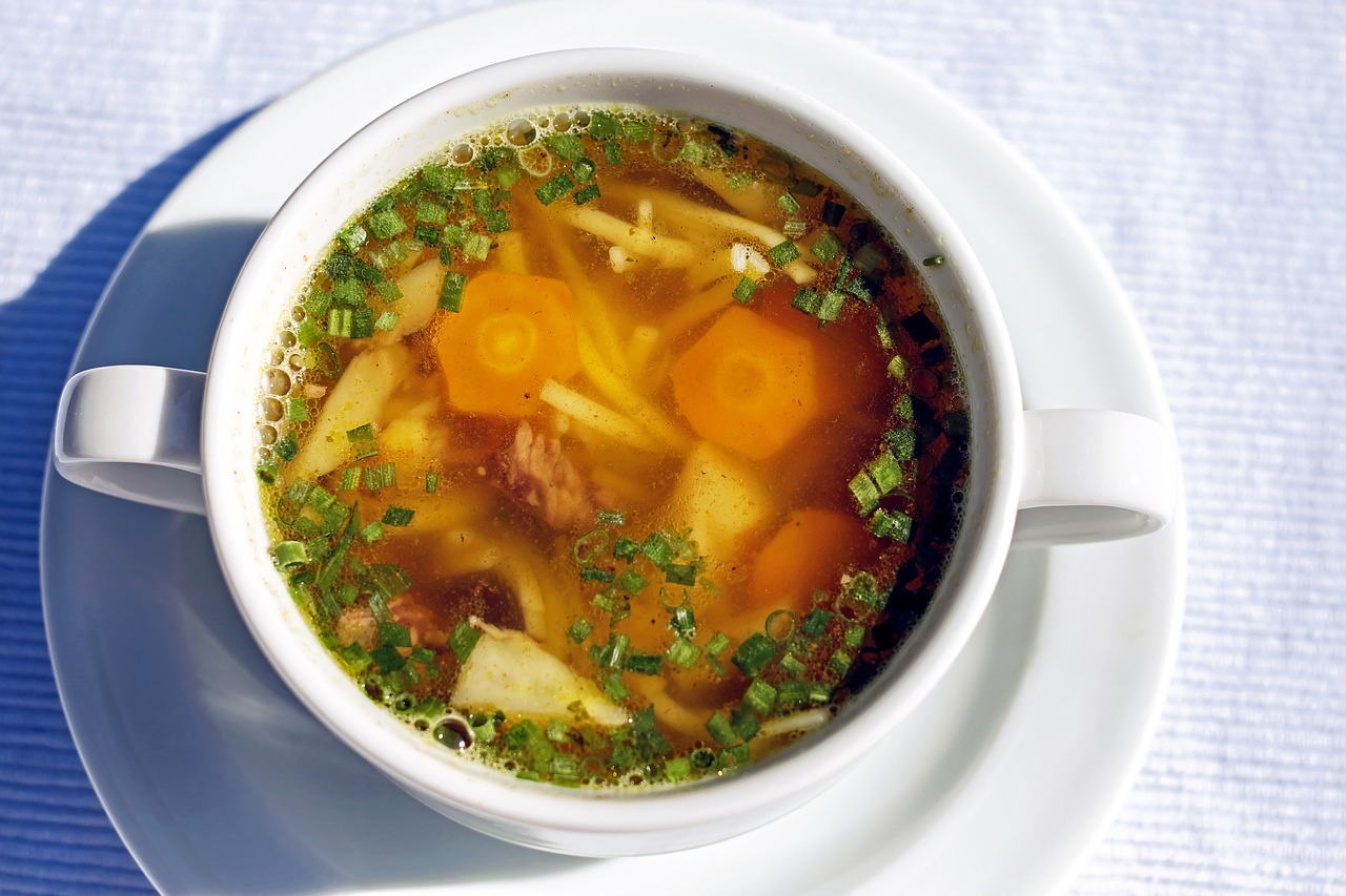 bowl of chicken soup with carrots and broth and parsley