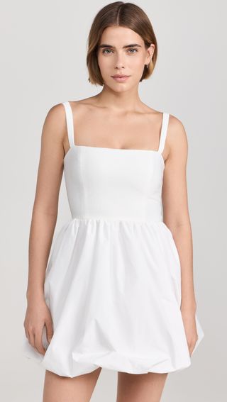 a model wears a white sleeveless dress with a bubble hem