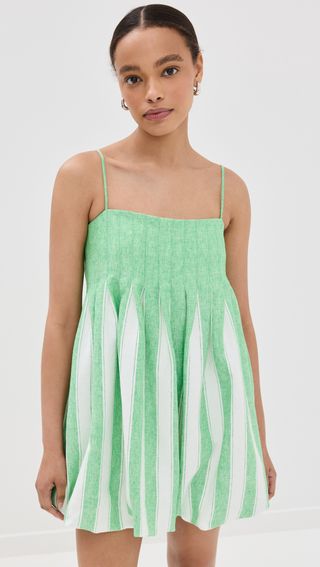 a model wears a green and white sleeveless dress with a bubble hem