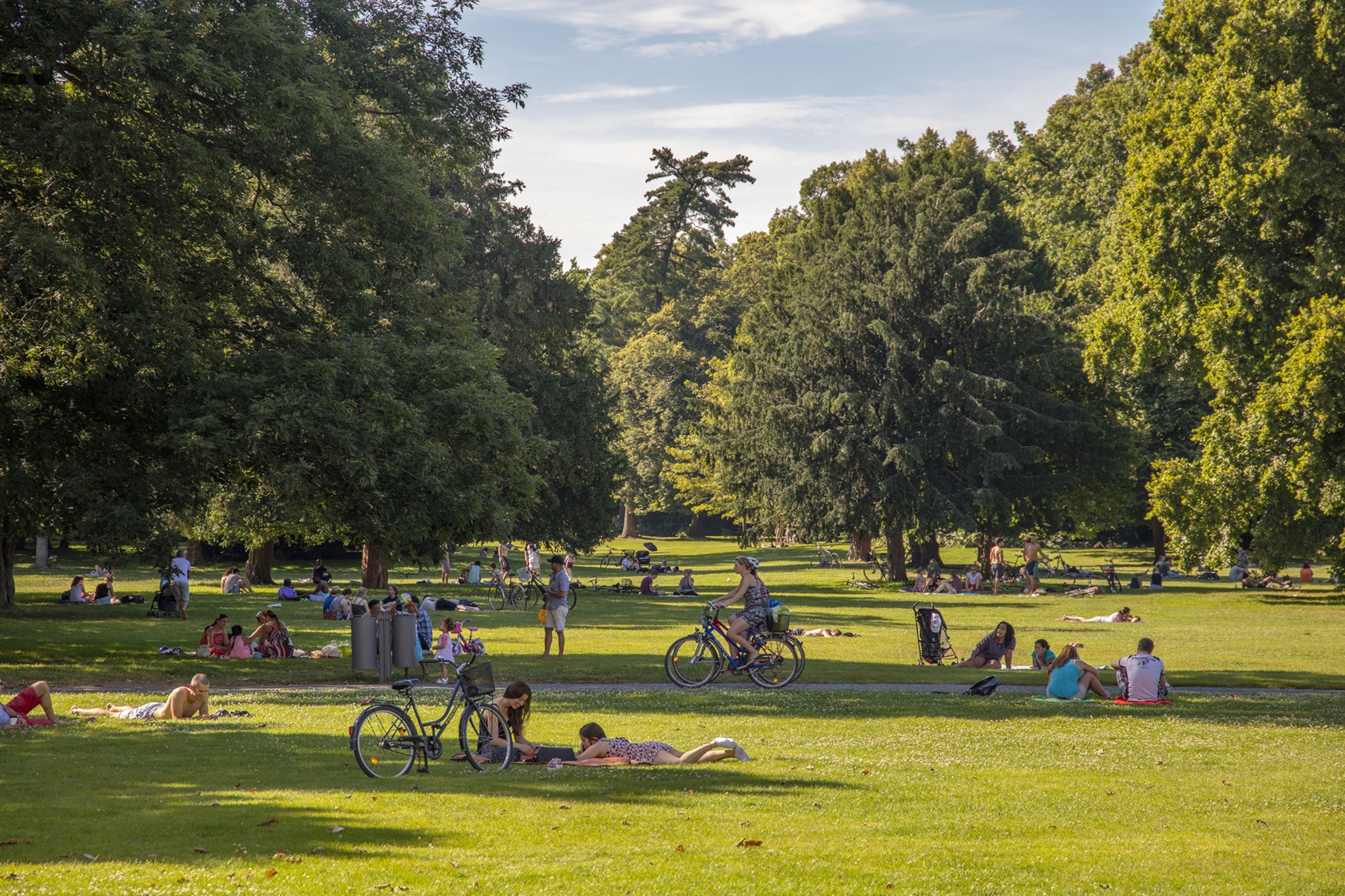 People relaxing on the grass in the Karlsruhe Palace Gardens in the state of Baden-Württemberg, Germany.