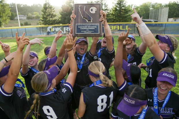 EL DORADO HILLS - Amador Valley pitcher Kaylee Davis (5) hoists the NorCal trophy whilst surrounded by teammates. Amador Valley defeated Oak Ridge-El Dorado Hills 13-11 in the CIF NorCal Division I championship softball game at Oak Ridge High School in El Dorado Hills, Calif. on June 1, 2024 (Joseph Dycus/Bay Area News Group)