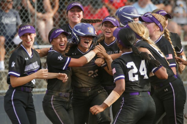 EL DORADO HILLS - Amador Valley player Mai Falcone (23) is mobbed by teammates after hitting a home run in the eighth inning. Amador Valley defeated Oak Ridge-El Dorado Hills 13-11 in the CIF NorCal Division I championship softball game at Oak Ridge High School in El Dorado Hills, Calif. on June 1, 2024 (Joseph Dycus/Bay Area News Group)