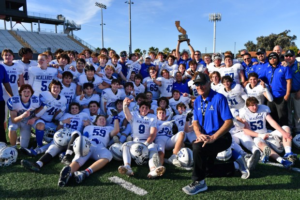 Acalanes head coach Floyd Burnsed poses for a photo with his players after defeating Birmingham during their CIF state football championship Division 3-AA game at Saddleback College in Mission Viejo, Calif., on Saturday, Dec. 9, 2023. Acalanes defeated Birmingham 35-23 to capture their first state title. (Jose Carlos Fajardo/Bay Area News Group)