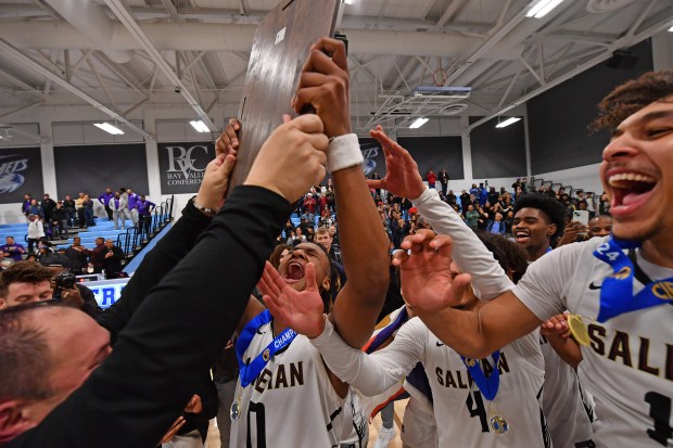 Salesian head coach Bill Mellis hands the first place plaque to Salesian's De' Undrae Perteete (0) after defeating Archbishop Riordan during their CIF NorCal Open Division championship game at Contra Costa College in San Pablo, Calif., on Tuesday, March 5, 2024. Salesian defeated Archbishop Riordan 49-44. (Jose Carlos Fajardo/Bay Area News Group)