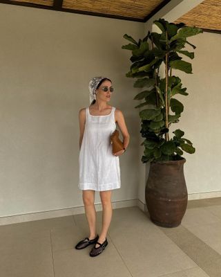 Woman wearing a white dress and Alaia flats