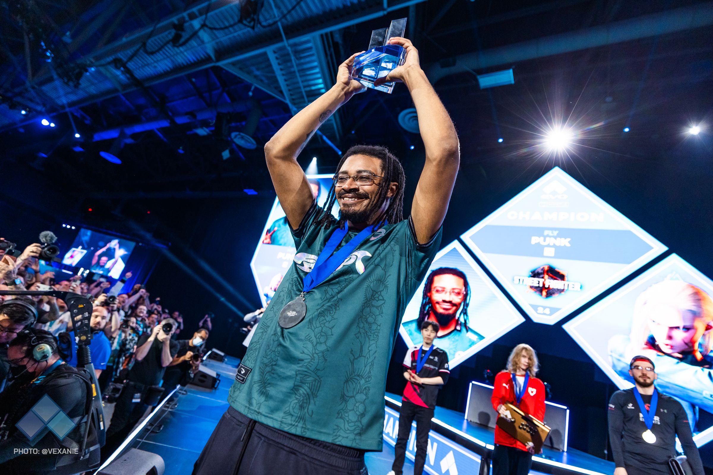 Photo from Evo 2024 featuring Victor “Punk” Woodley holding up his trophy for Street Fighter 6.