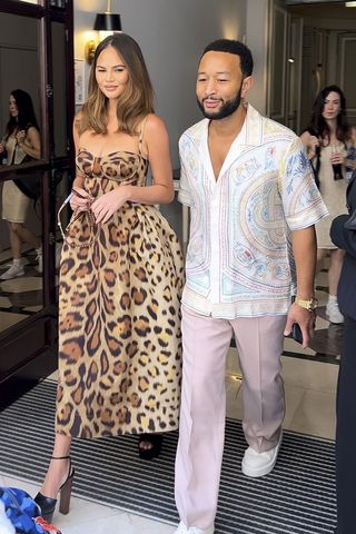 Chrissy Teigen wearing a leopard print dress with John Legend