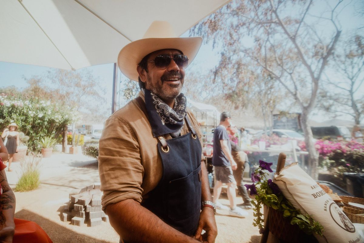 Baja California chef Javier Placencia stands in front of a grill.