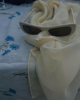 A soft yellow headscarf and white sunglasses.