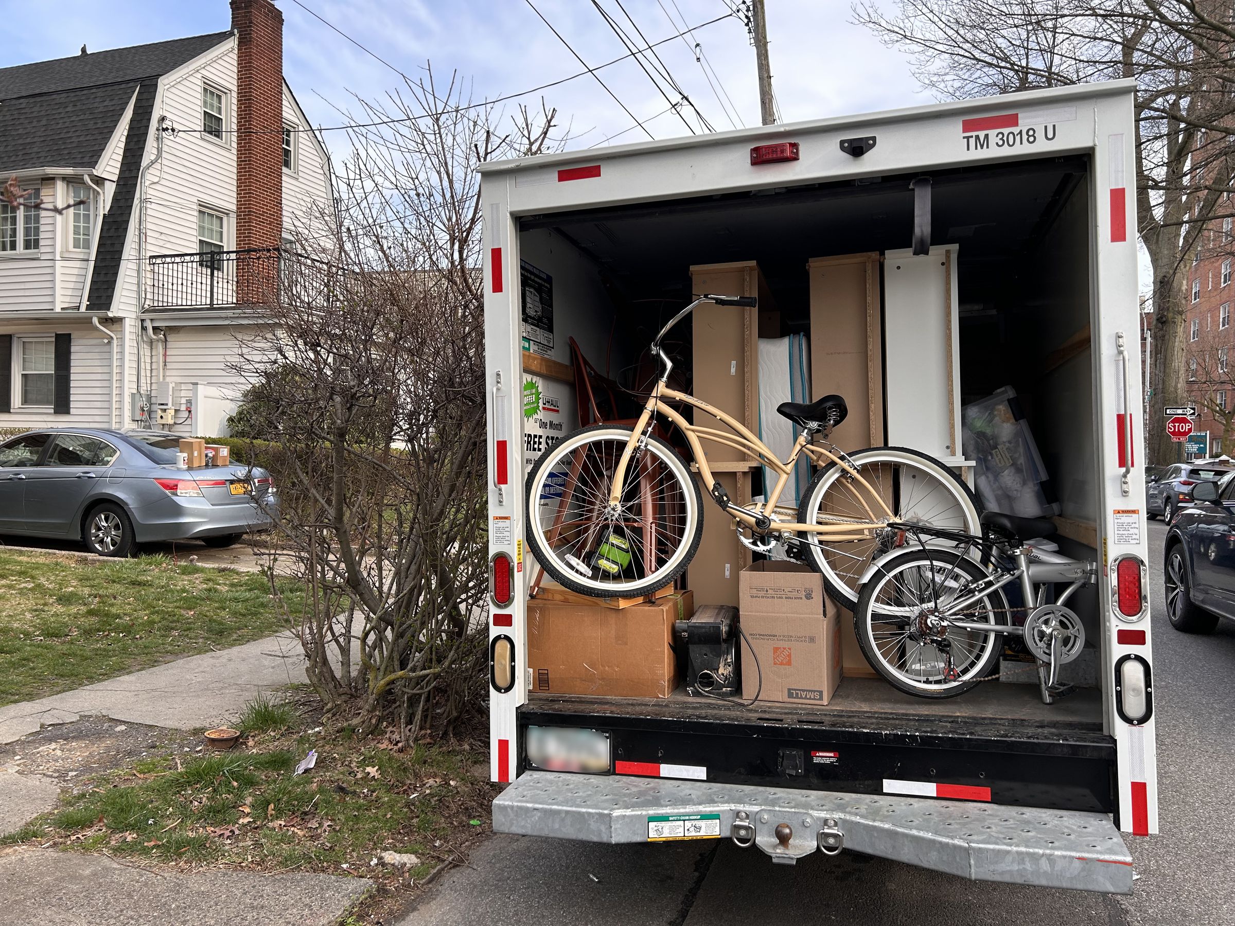 Back view of loaded U-Haul truck outside home, moving day, Queens, New York