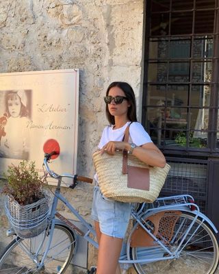 @leasy_inparis wearing a Loewe raffia bag with a bikini and trousers