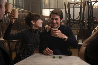 Lily Collins and Lucas Bravo hold up drinks in a scene from Emily in Paris