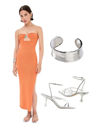 A woman wearing an orange dress, silver cuff, silver heels