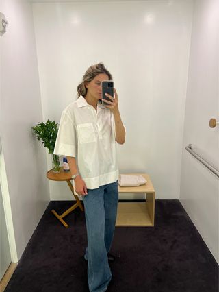 Eliza Huber wearing a white poplin short-sleeve shirt and jeans at the COS store.