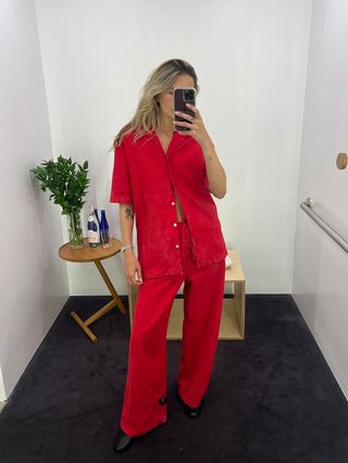 Eliza Huber wearing a red button-down denim short-sleeve shirt and matching baggy jeans at the COS store.