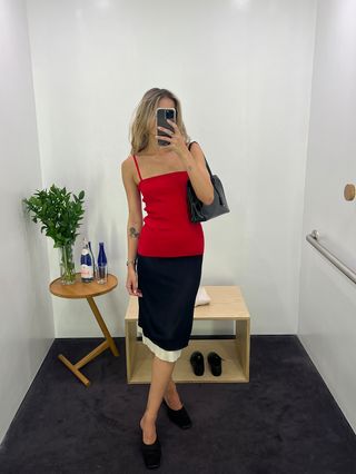 Eliza Huber wearing a red spaghetti-strap top with a black and cream pencil skirt at the COS store.