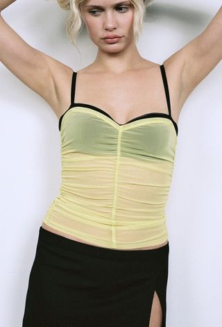 a model wears a yellow ruched tube top