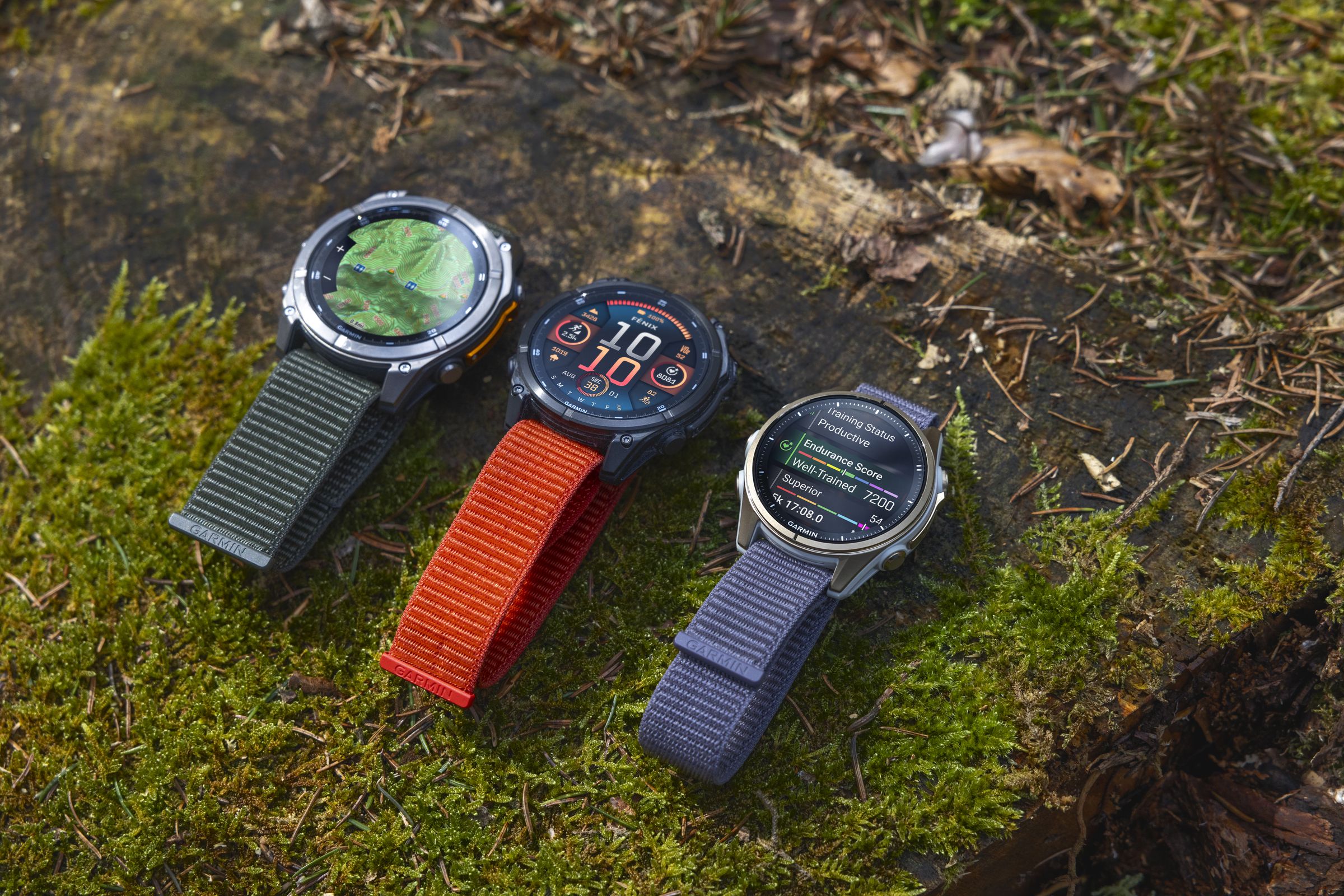 Three of the Garmin Fenix 8 models side by side on grass