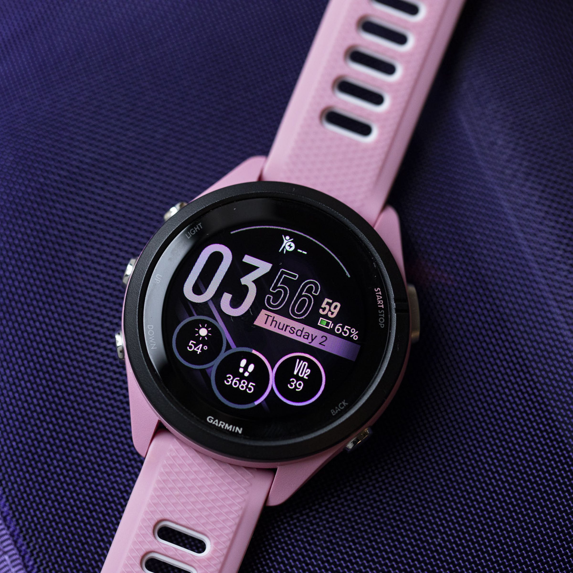 Close-up of the Garmin Forerunner 265S’s OLED display and watchface on a purple background