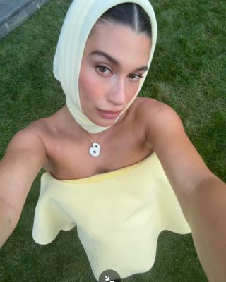 Hailey Bieber in yellow headscarf and dress